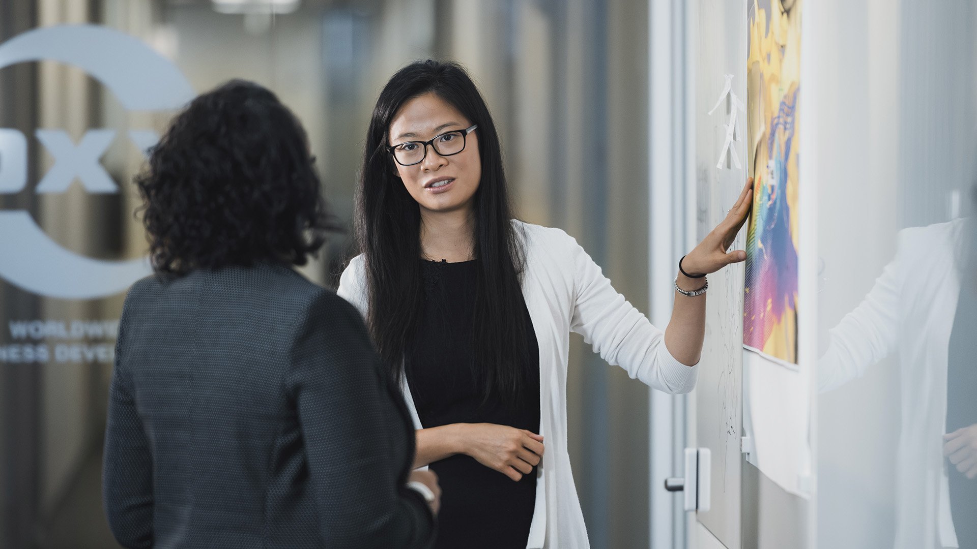 Two female Oxy employees at white board