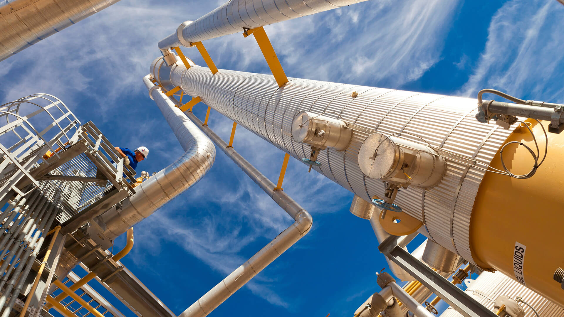 Male Oxy employee looking down at midstream plant 